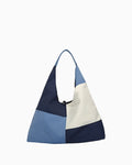 Calm sea–inspired patchwork shoulder bag featuring layered blue fabric panels, visible stitching, soft texture, and a relaxed casual silhouette