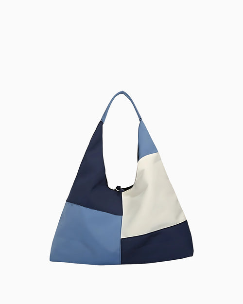 Calm sea–inspired patchwork shoulder bag featuring layered blue fabric panels, visible stitching, soft texture, and a relaxed casual silhouette